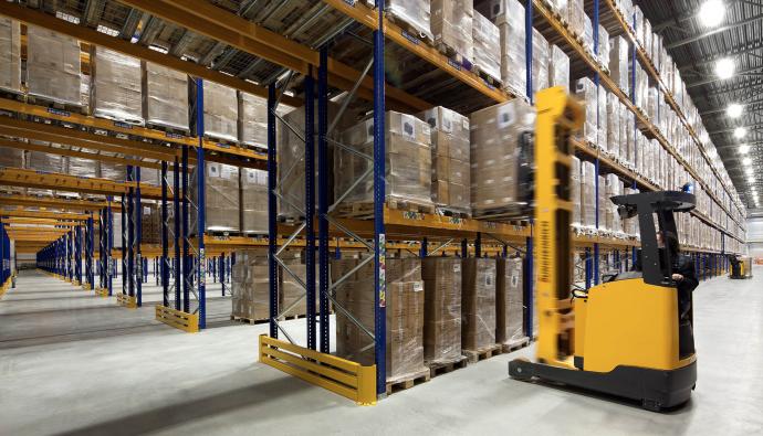 Reachtruckchauffeur rijdt door warehousegang | Werken bij Seacon Logistics