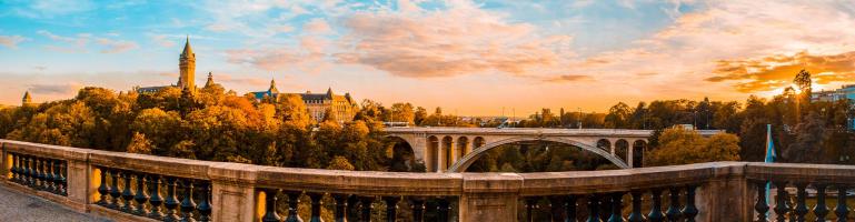 Luxemburg stad bij zonsopkomst met daarop o.a. de Adolfsbrug waarop verkeer rijdt. | Transport Luxemburg | Seacon Logistics