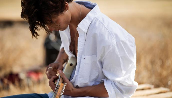 Mann mit weißer Bluse spielt ein Instrument | Seacon Logistics