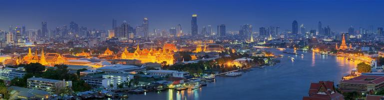 Panoramafoto der Skyline von Bangkok am Fuße des Menam-Flusses und des hell erleuchteten Thronsaals des Chakri Maha Prasat | Transport Thailand | Seacon Logistics